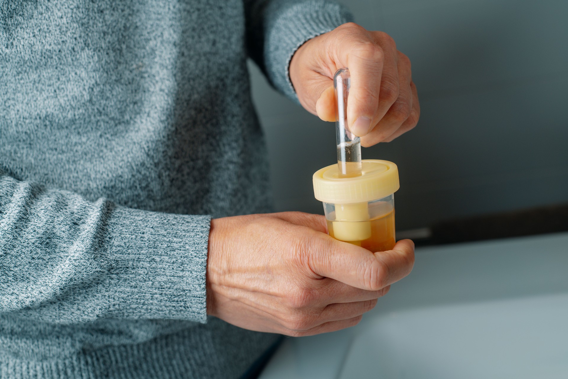 a man is filling a tube with a urine sample